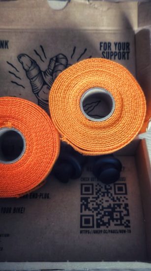 Innenansicht der Verpackung mit 2x orangem Lenkerband und der Kurzanleitung
